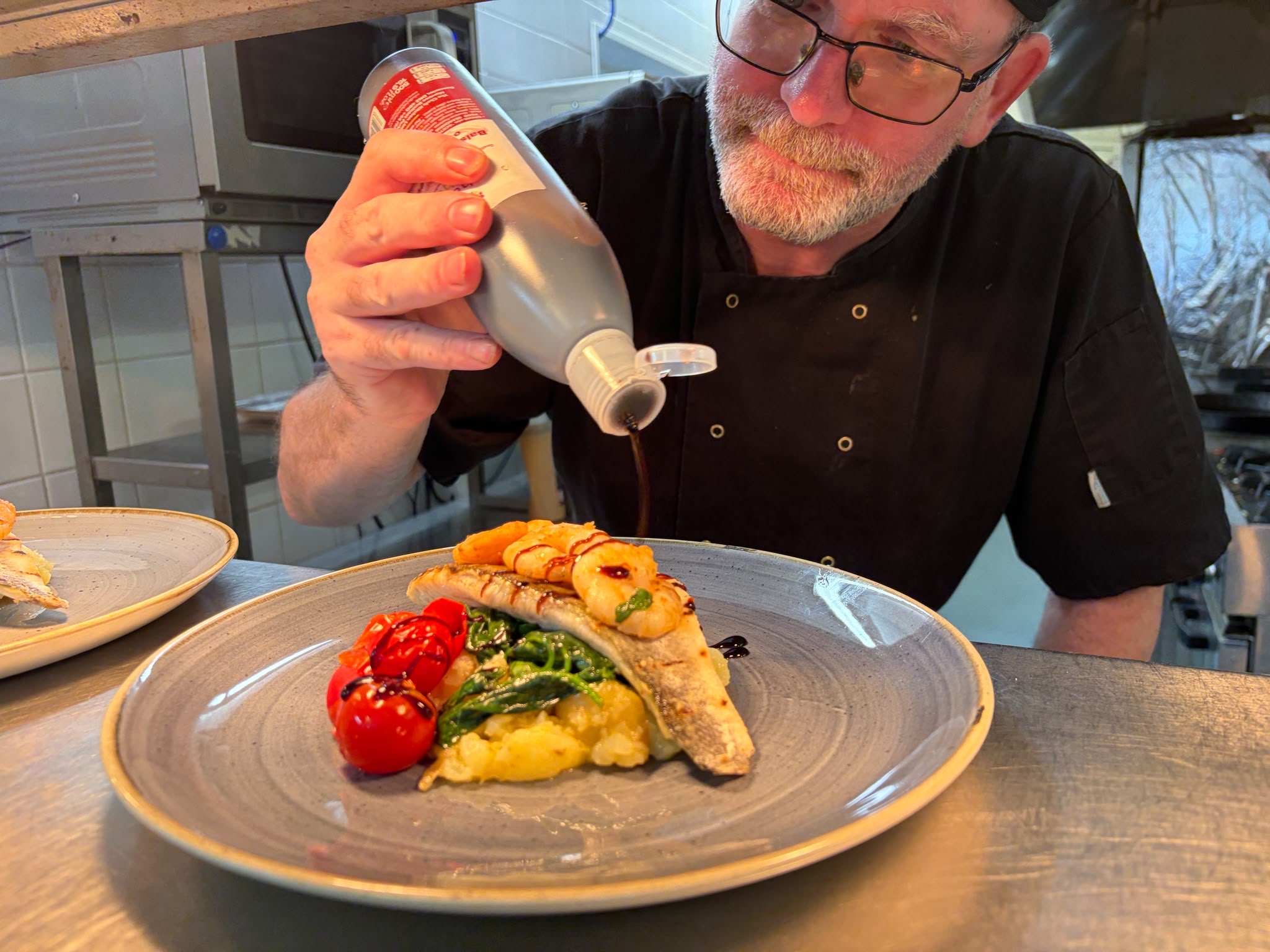 Chef John Brett finishing a sea bass plate