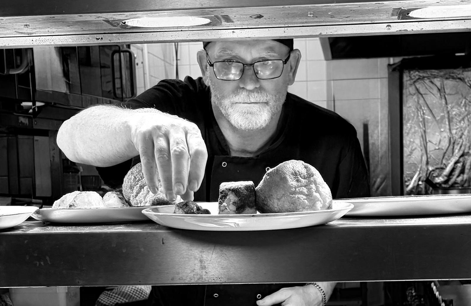 Chef John Brett plating dishes in a professional kitchen