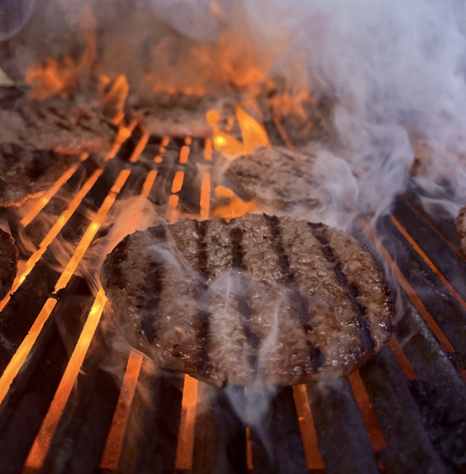 Steak cooking over flames on the grill